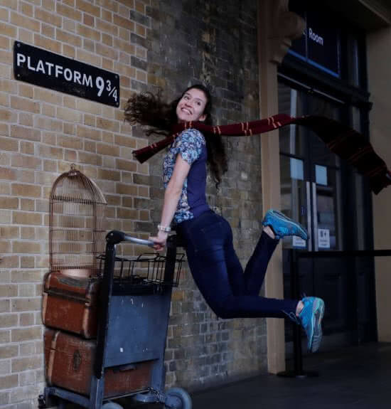 A woman passes through Platform 9¾ barrier at Kings Cross station