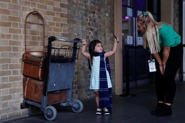 A child pushes the trolley into the barrier at King Cross platform 9¾